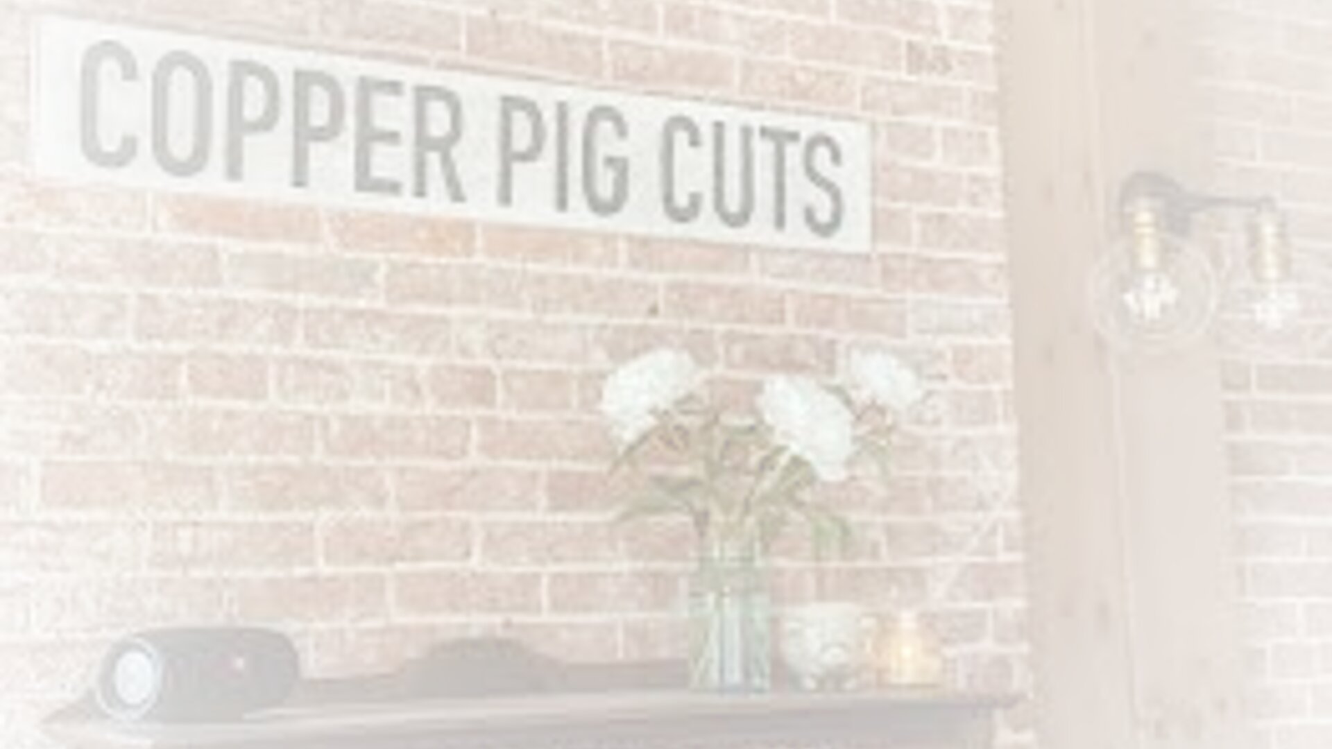 Copper Pig Cuts salon interior with rustic brick walls